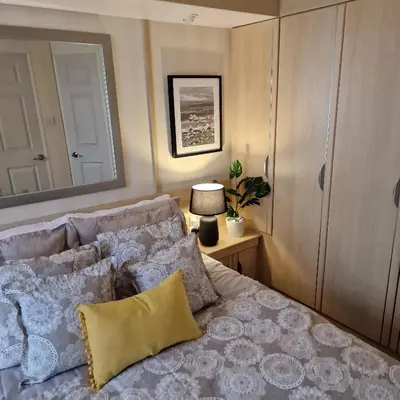 a bedroom with a bed and a mirror at Sunshine Atlas Glamping Retreat in Jaywick Sands