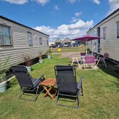a group of chairs and a table in a yard at Sunshine Atlas Glamping Retreat in Jaywick Sands