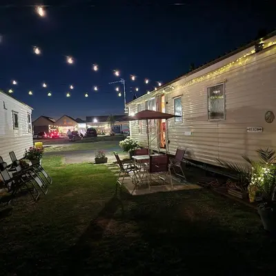 a group of chairs and a table next to a trailer at Sunshine Atlas Glamping Retreat in Jaywick Sands