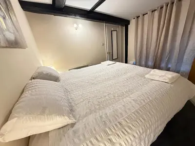 a bedroom with a large white bed with a window at Apartment - Sleeps 2 - Parking - WiFi in Colchester