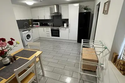a kitchen with white cabinets and a black refrigerator at Apartment - Sleeps 2 - Parking - WiFi in Colchester