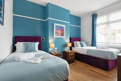 two beds in a room with blue walls at Welcome to Northview House Stylish 4 Bedroom Home in Southend by Jesswood Properties Contractors Corporates Relocation Stays Long Stays Welcome in Southend-on-Sea