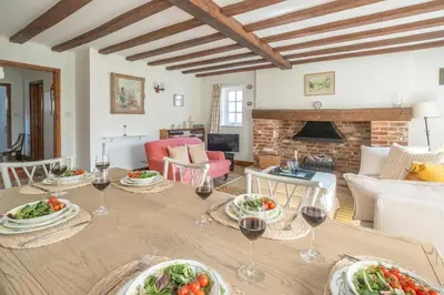 a dining room with a table with glasses of wine at Harvest Cottage in Aldeburgh