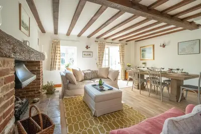 a living room with a couch and a table at Harvest Cottage in Aldeburgh