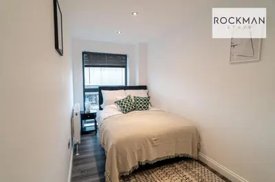 a small bedroom with a bed and a window at Royal Oak Apartments 1 - Free Van Parking - 2 Bedroom Apartment - 2 bathrooms - Sleeps 6 - Perfect for Contractors - Fast Wi-fi in Brentwood