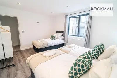 a room with two beds and a window at Royal Oak Apartments 1 - Free Van Parking - 2 Bedroom Apartment - 2 bathrooms - Sleeps 6 - Perfect for Contractors - Fast Wi-fi in Brentwood