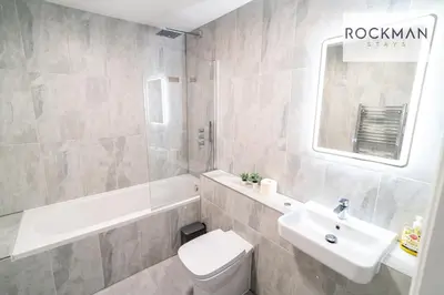 a bathroom with a sink and a toilet and a tub at Royal Oak Apartments 1 - Free Van Parking - 2 Bedroom Apartment - 2 bathrooms - Sleeps 6 - Perfect for Contractors - Fast Wi-fi in Brentwood