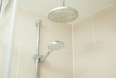 a shower with a shower head in a bathroom at White Hart Hotel by Greene King Inns in Braintree