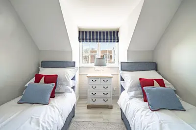 two twin beds in a room with a window at 4 Truman Lodge in Thorpeness
