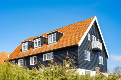 a black house with an orange roof at 4 Truman Lodge in Thorpeness