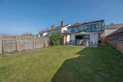 a house with a yard with a fence at Melody Cottage in Aldeburgh
