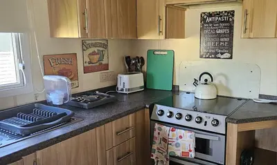 a kitchen with a stove and a counter top at J.R. Holiday Homes in Clacton-on-Sea