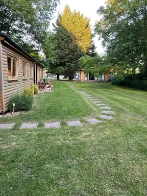 a grass yard with stepping stones in front of a house at Kendall Lodge in Burwell