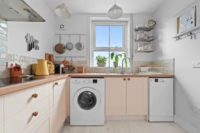 a kitchen with a washing machine and a window at St John's Corner Cottage, Bury St. Edmunds in Bury Saint Edmunds