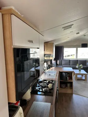 a kitchen with a stove and a living room at 13 Chorley close in Walton-on-the-Naze