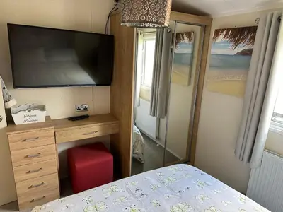 a bedroom with a bed and a dresser with a television at 13 Chorley close in Walton-on-the-Naze