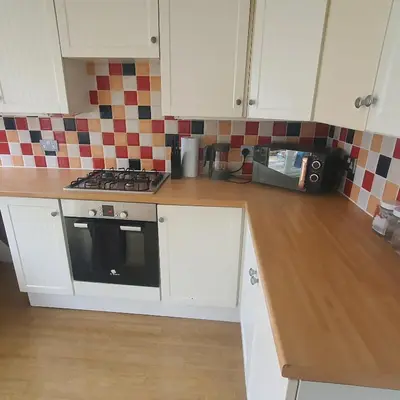 a kitchen with white cabinets and a stove at Beautiful and Cozy 2 Bedroom Apartment Billericay in Billericay