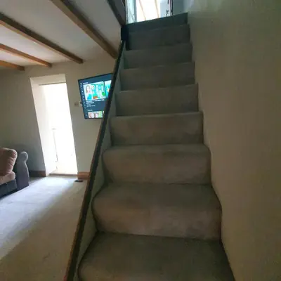 a staircase in a house with a couch and a television at Beautiful and Cozy 2 Bedroom Apartment Billericay in Billericay