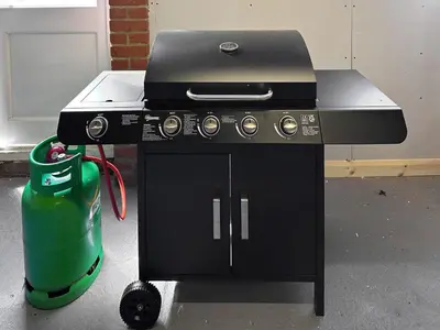 a black stove with a green bucket next to it at The Great Escape in Ipswich