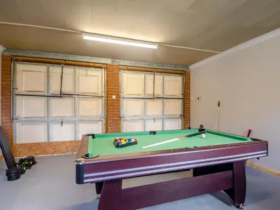 a room with a pool table and two windows at The Great Escape in Ipswich