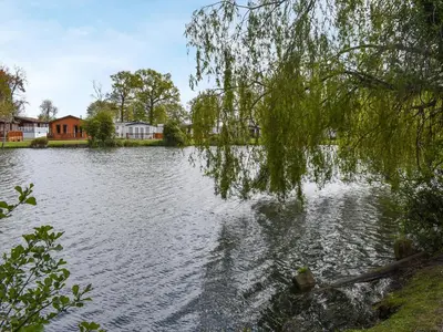 a view of a lake with houses and trees at Forest Retreat in Saxmundham