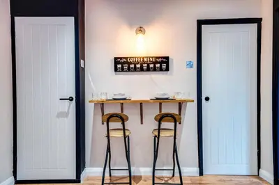 a bar with two stools next to two doors at Stylish Victorian house, close to City Centre in Colchester