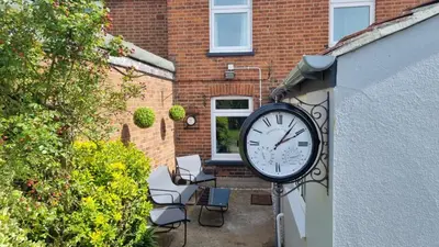a clock attached to the side of a building at Stylish Victorian house, close to City Centre in Colchester