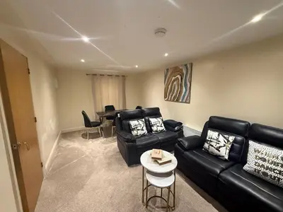 a living room with a couch and a table at Comfort Arena in Colchester