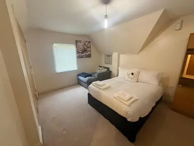 a bedroom with a large bed and a couch at Comfort Arena in Colchester