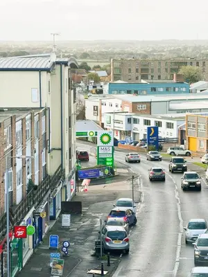 a city with cars parked on a street with buildings at Urban Oasis in Billericay