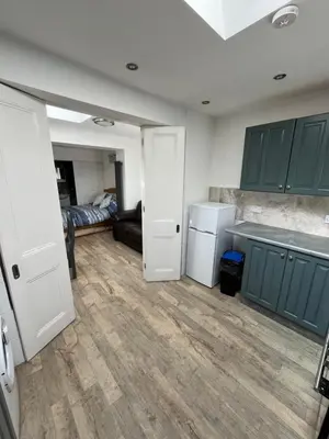 a kitchen with green cabinets and a white refrigerator at Seagull studio in Felixstowe