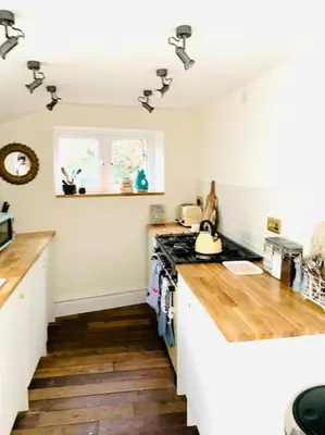 a kitchen with a stove and a counter top at The Yellow cottage on the hill. in Framlingham
