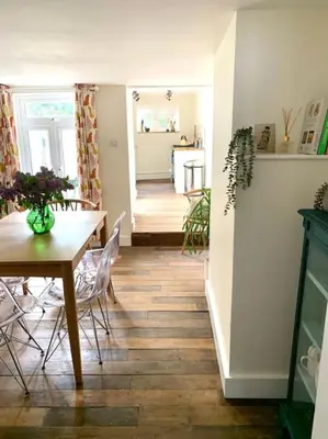 a dining room and kitchen with a table and chairs at The Yellow cottage on the hill. in Framlingham