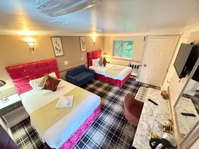 a hotel room with two beds and a couch at 4 Sisters Inn in Theydon Bois
