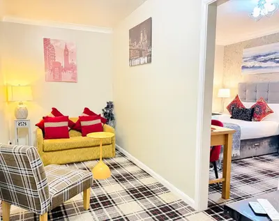 a living room with a couch and a bed in a room at 4 Sisters Inn in Theydon Bois
