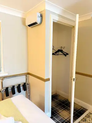 a small room with a bed and a closet at 4 Sisters Inn in Theydon Bois