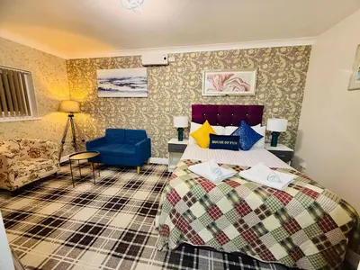a bedroom with a bed and a blue chair at 4 Sisters Inn in Theydon Bois