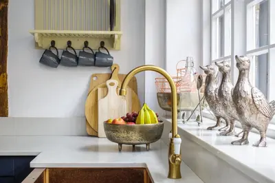 a kitchen counter with a bowl of fruit and birds at Luxury 3 Bed Manor House Hot Tub Cinema Room SkyTV in Saffron Walden
