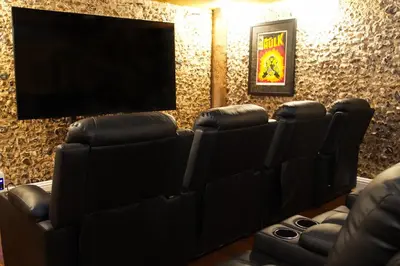 a cinema room with leather chairs and a flat screen tv at Luxury 8 Bed Manor House Hot Tub Cinema Room SkyTV in Saffron Walden