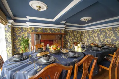 a dining room with a blue table with food on it at Luxury 8 Bed Manor House Hot Tub Cinema Room SkyTV in Saffron Walden