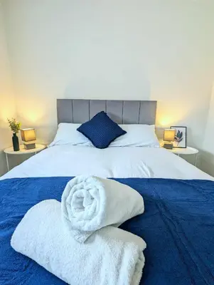 a bedroom with a bed with two towels on it at 3-Bed, Sleeps 5, 3 Bath, Parking, WiFi in Watton