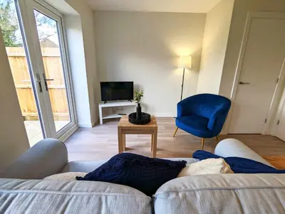 a living room with a couch and a blue chair at 3-Bed, Sleeps 5, 3 Bath, Parking, WiFi in Watton