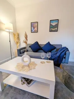 a living room with a white table with two wine glasses at 2-Bed, Sleeps 5, 2 Bath, Parking, WiFi in Colchester