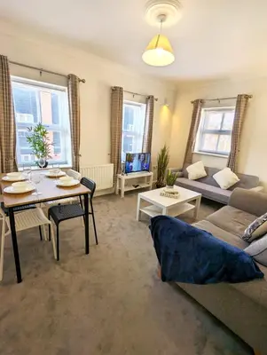 a living room with a couch and a table at 2-Bed, Sleeps 5, 2 Bath, Parking, WiFi in Colchester