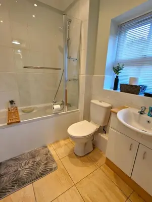 a bathroom with a toilet and a sink and a shower at 2-Bed, Sleeps 5, 2 Bath, Parking, WiFi in Colchester
