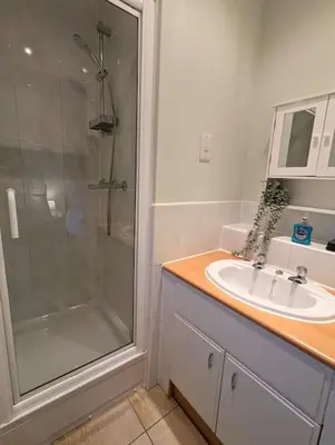 a bathroom with a glass shower and a sink at 2-Bed, Sleeps 5, 2 Bath, Parking, WiFi in Colchester
