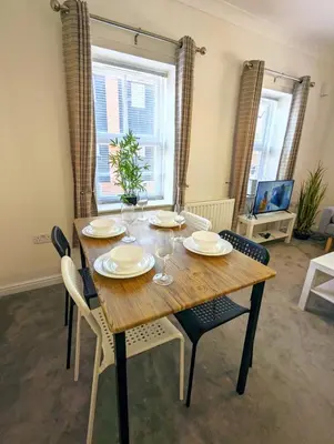 a dining room with a wooden table and chairs at 2-Bed, Sleeps 5, 2 Bath, Parking, WiFi in Colchester