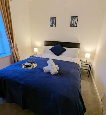 a bedroom with a blue bed with a tray on it at 2-Bed, Sleeps 5, 2 Bath, Parking, WiFi in Colchester