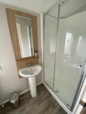 a bathroom with a sink and a glass shower at VerbZen Holiday Caravan at St Osyth Beach, Clacton-on-Sea by Verb Holidays in Saint Osyth
