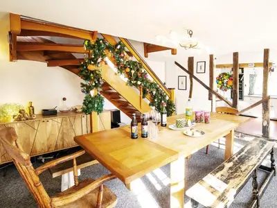 a dining room with a wooden table and a staircase at Prospect Place by The Suffolk Cottage Collection in Westleton